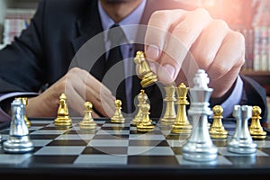 Chess game on chess board behind business man background. Business concept to present financial information and marketing strategy