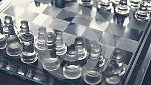 Chess game. Chess pieces made of glass. Rivalry concept. Selective focus included