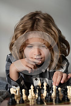 Chess game with children at home. Little kid play chess. Thinking child. Chess game for kids. Intelligent, smart and
