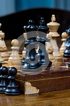 Chess game, close up of a black king and queen, other figures in the front