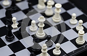 Chess game middlegame on chessboard. Black and white figure positioning. Chess figurine order. Checkmate game