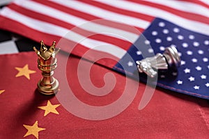 Chess game. Pawns with golden crown stand as winner over the knight on China and USA national flags. Trade war concept