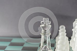 Chess with game pieces made of glass, queen, king, pawn and game board made of glass