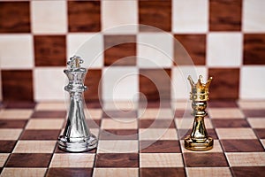 Chess game. Small pawn wearing golden crown stand confront the king. Business competitive and challenging