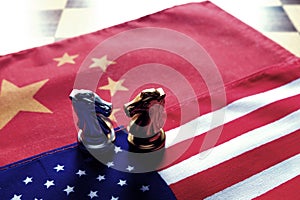 Chess game. Two knights face to face on Chinese and American national flags. Trade war and conflict between two big countries. USA