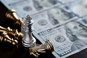 Chess King stand over the enemies with US dollar banknote. The winner in business competition. Competitiveness and strategy