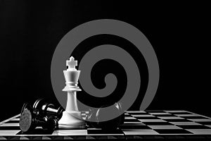 Chess king standing wins the game of chess setup on dark background. Chess concept save the king and save the strategy, game over
