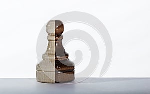 Chess pawn in white and black color standing alone on the table