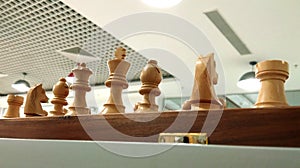 Chess piece on chess board with ceiling decoration background.