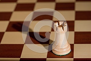 Chess piece - a white rook on a chessboard.