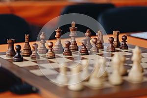 Chess pieces on a boart ready to play a game. Wood pieces of a game of chess on a board photo