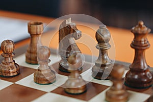 Chess pieces on a boart ready to play a game. Wood pieces of a game of chess on a board photo