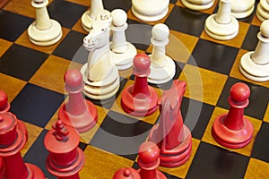 Chess pieces in red and white color over the table.