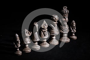 Chess pieces in a row on a black background