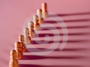 chess pieces in a row, white pawns on a pink background,