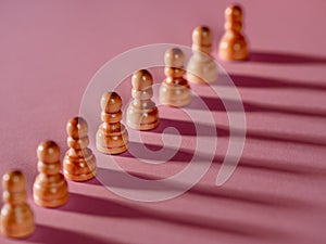 chess pieces in a row, white pawns on a pink background,