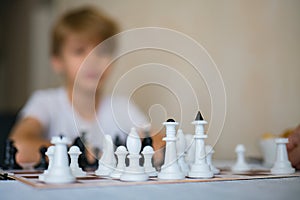 Chess pieces set on a chessboard. Boy playing chess board. Concentrated young boy enjoying playing chess