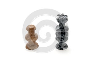 Chess pieces, white pawn and black queen face off