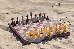 Chess play on the board at the beach. Chessboard on the sand on a sunny day