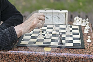 Chess player in the park. Old man plays chess in the park