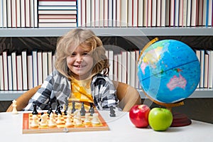 Chess school for children. Clever concentrated and thinking child playing chess. Child boy developing chess strategy