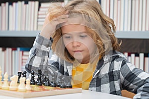 Chess school. Little kid play chess. Thinking child. Chess game for kids. Intelligent, smart and clever school boy.