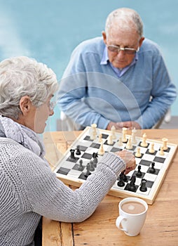 Chess, strategy and old couple thinking while playing a board game in the backyard or bonding together. Mind, relax or