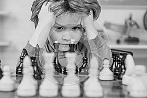 Chess, success and winning. Clever concentrated and thinking child while playing chess. Kids educational games, child