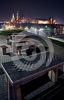 Chess tables at the background of Wawel Castle at night