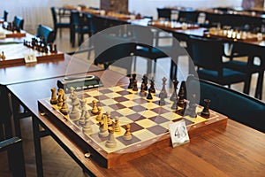 Chess tournament, kids and adults participate in chess match game outdoors in indoor hall, players of all ages play, competition