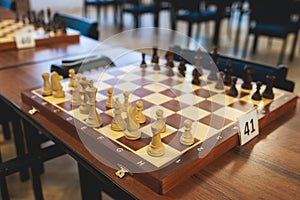 Chess tournament, kids and adults participate in chess match game outdoors in indoor hall, players of all ages play, competition