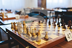 Chess tournament, kids and adults participate in chess match game outdoors in indoor hall, players of all ages play, competition