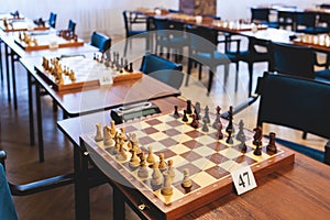 Chess tournament, kids and adults participate in chess match game outdoors in indoor hall, players of all ages play, competition