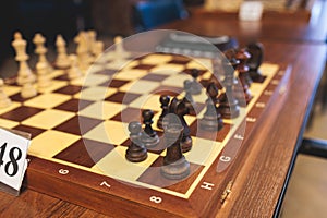 Chess tournament, kids and adults participate in chess match game outdoors in indoor hall, players of all ages play, competition