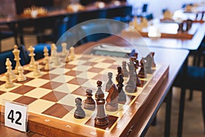 Chess tournament, kids and adults participate in chess match game outdoors in indoor hall, players of all ages play, competition