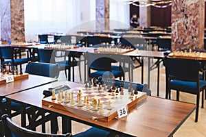 Chess tournament, kids and adults participate in chess match game outdoors in indoor hall, players of all ages play, competition