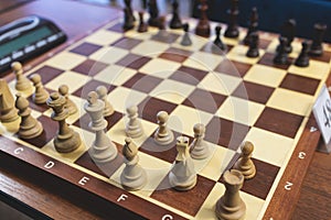 Chess tournament, kids and adults participate in chess match game outdoors in indoor hall, players of all ages play, competition