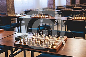 Chess tournament, kids and adults participate in chess match game outdoors in indoor hall, players of all ages play, competition