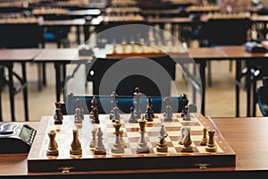 Chess tournament, kids and adults participate in chess match game outdoors in indoor hall, players of all ages play, competition