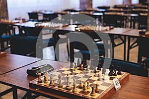 Chess tournament, kids and adults participate in chess match game outdoors in indoor hall, players of all ages play, competition