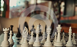 Chessboard and chess pieces on a green wooden table in a cafe