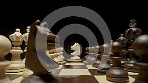 Chessboard with chess pieces placed on an isolated black background. White and brown wooden chess set on squared board