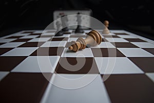 Chessboard with a defeated figure of the king, the game is over