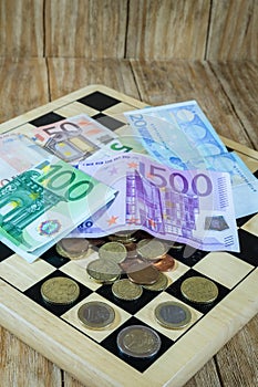 A chessboard, figures and money