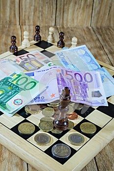 A chessboard, figures and money