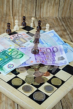 A chessboard, figures and money