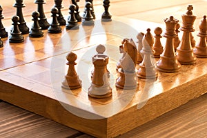 Chessboard with figures on a wooden table. Selective focus