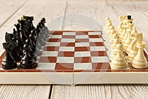 Chessboard with figures on a wooden table. Selective focus