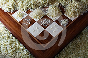 Chessboard with growing heaps of rice grains, view from above sh