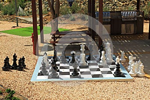 Chessboard with huge black and white chess figures for outdoor playing